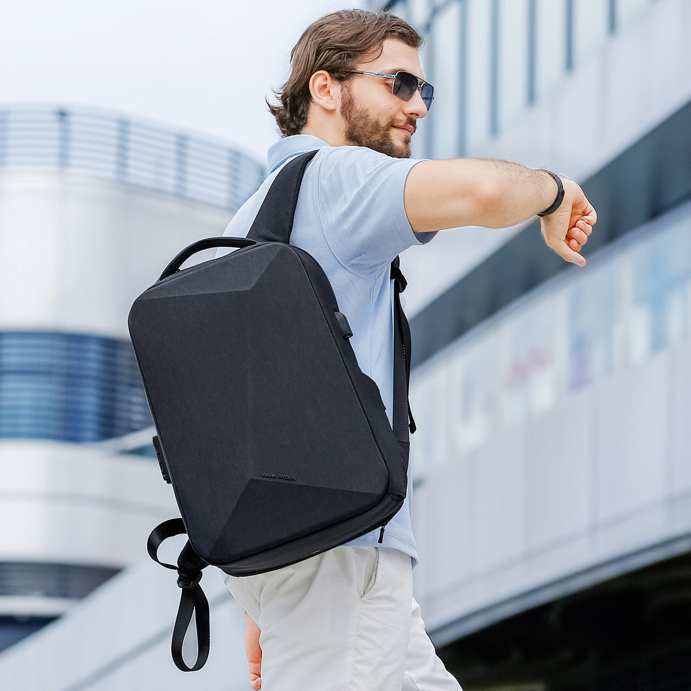 Man wearing Mark Ryden Cache USB Charging backpack in black. 