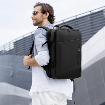 Man wearing Mark Ryden Infinity XL Rain usb charging business / travel backpack. 